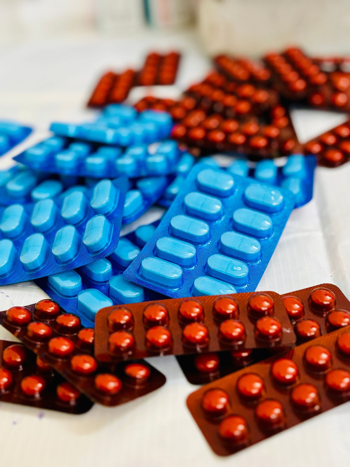 Blue, red and orange tablets in blister strips